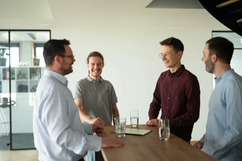 Foto aus dem Büro der RAUSCH Technology GmbH in Würzburg, auf dem Sven Rausch, Luca Gerhard, Daniel Wilhelm und Janßen beim Austausch von Informationen zu sehen sind.