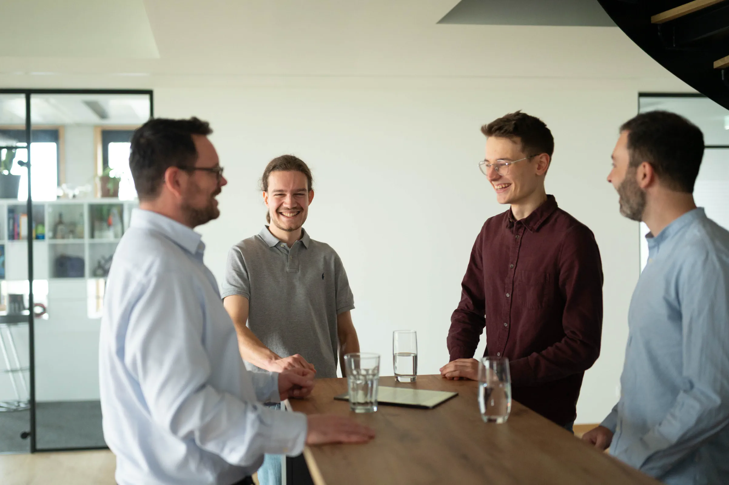 Foto aus dem Büro der RAUSCH Technology GmbH in Würzburg, auf dem Sven Rausch, Luca Gerhard, Daniel Wilhelm und Janßen beim Austausch von Informationen zu sehen sind.